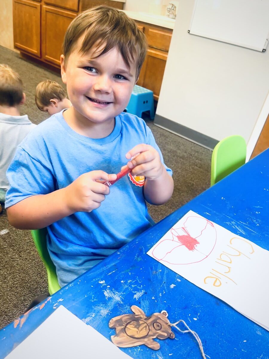 Smiling boy proudly showing his drawing
