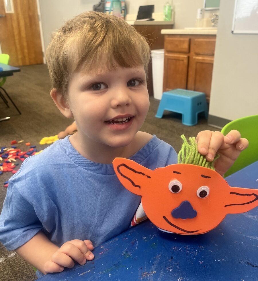 Young preschool boy with a fox puppet craft he made