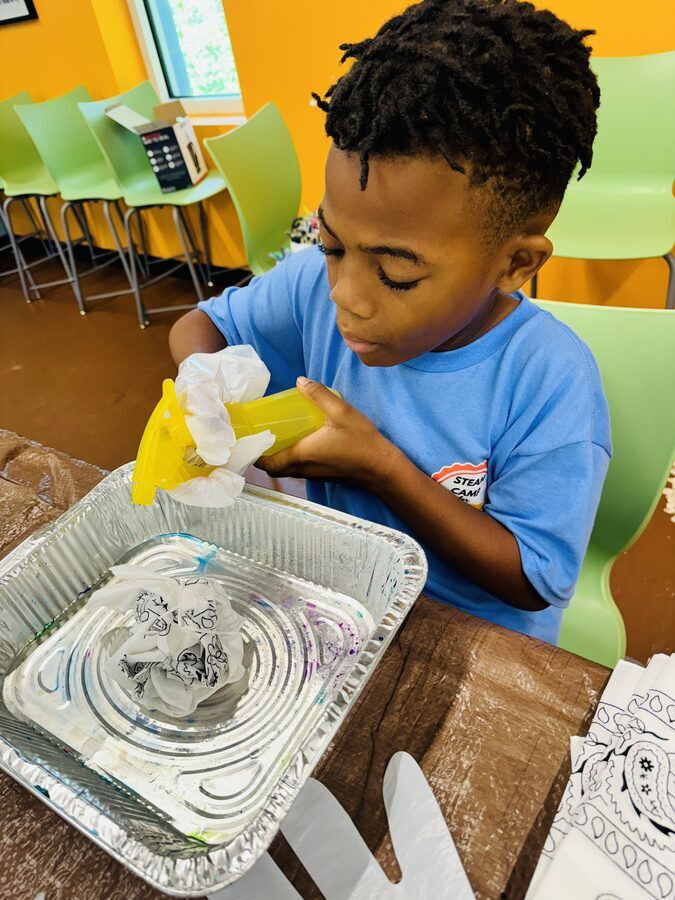 Boy doing a marbling art project at STEAMCamp
