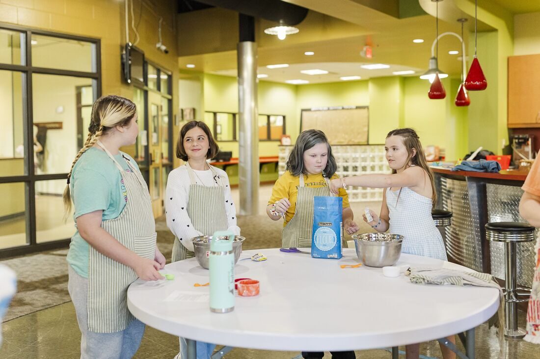 Girls in aprons doing a cooking science experiment