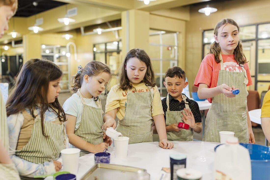 Kids in aprons learning food science at STEAMCamp