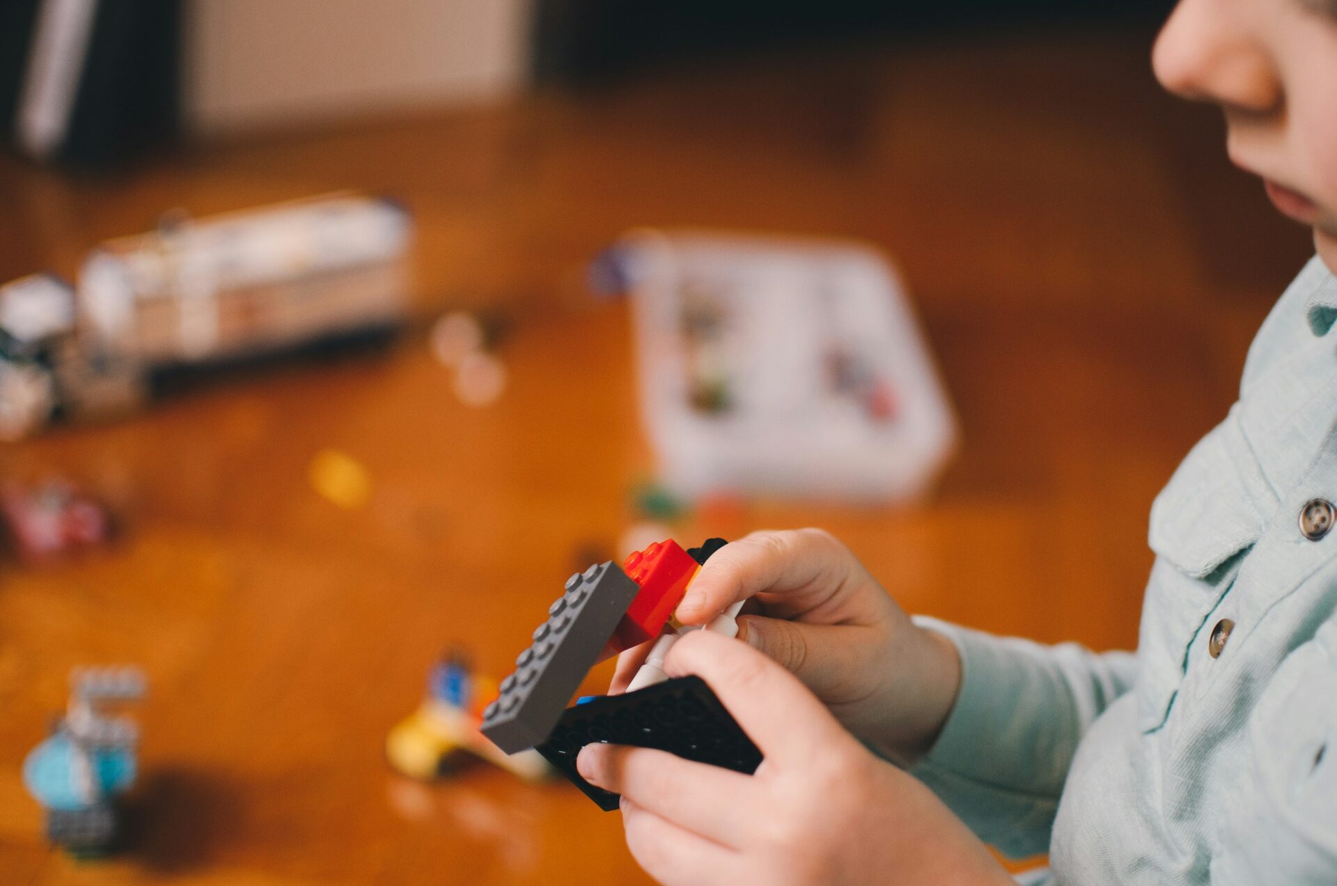 Child building with LEGO bricks during a hands-on STEAM curriculum lesson