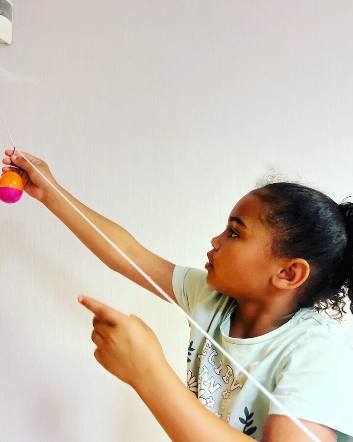 Girl experimenting with a pendulum at STEAMCamp